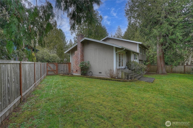 view of side of home with a fenced backyard, a chimney, and a yard