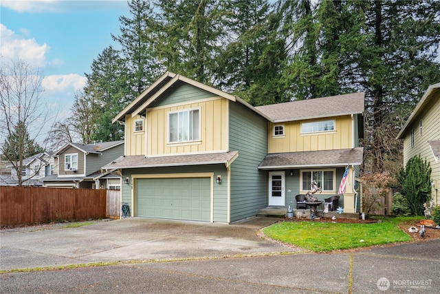 view of front facade featuring board and batten siding, a front lawn, fence, driveway, and an attached garage