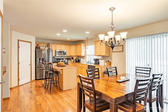 dining space with light wood-style flooring, recessed lighting, and a chandelier