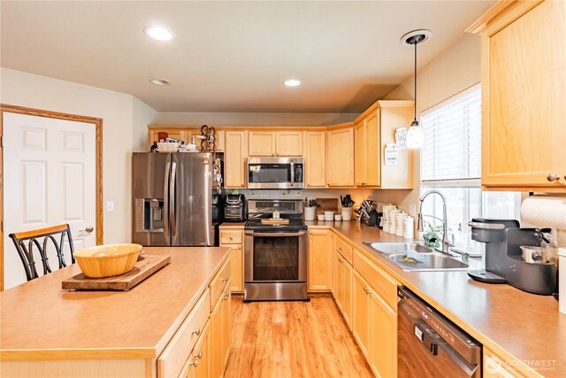 kitchen featuring recessed lighting, a sink, light brown cabinetry, stainless steel appliances, and light wood-style floors