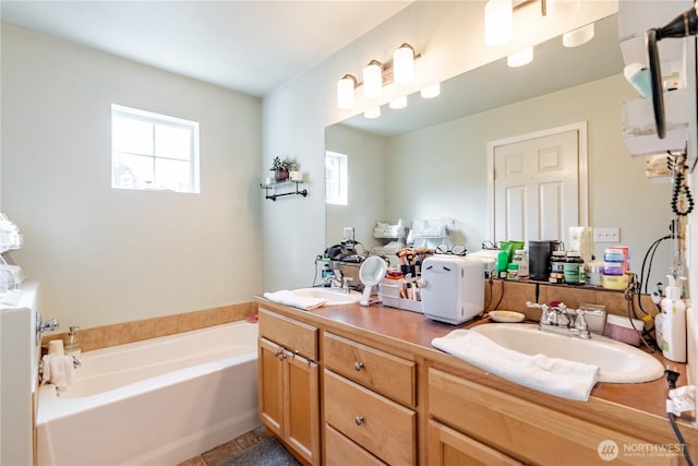 bathroom with a sink, a healthy amount of sunlight, and a bath