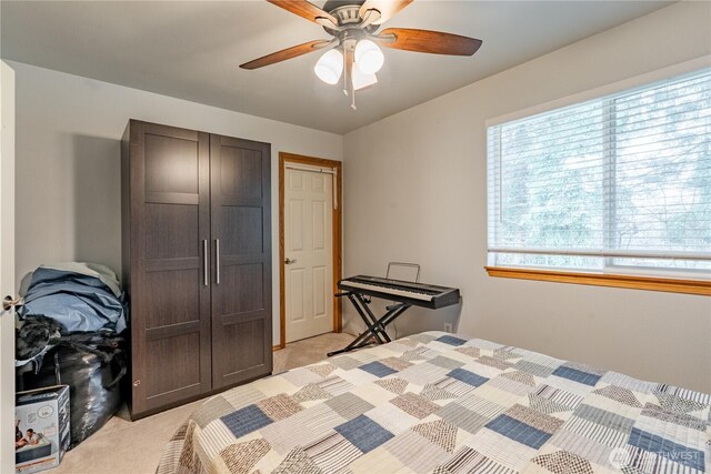 bedroom with light carpet and a ceiling fan