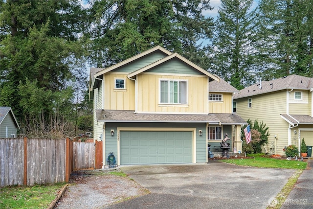 view of front facade with fence, an attached garage, a shingled roof, aphalt driveway, and board and batten siding