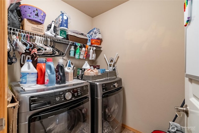 washroom with laundry area, washing machine and dryer, and baseboards