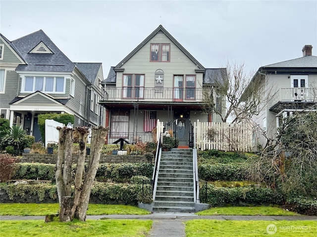 view of front of house with stairs and a balcony