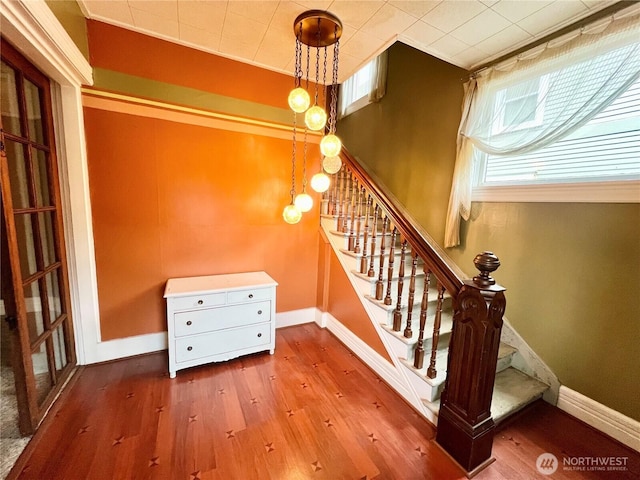 stairs featuring ornamental molding, baseboards, and wood finished floors