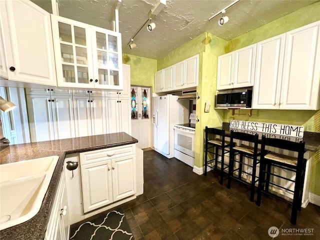 kitchen featuring white appliances, a sink, and white cabinets