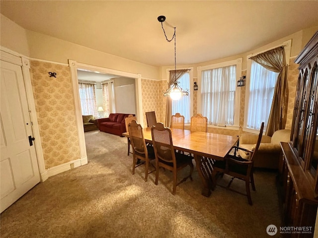 carpeted dining room with wallpapered walls