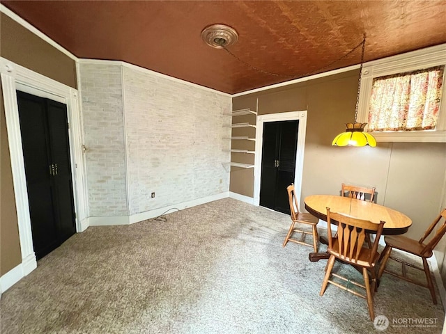 carpeted dining area with brick wall