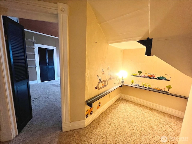 hallway featuring carpet flooring and baseboards