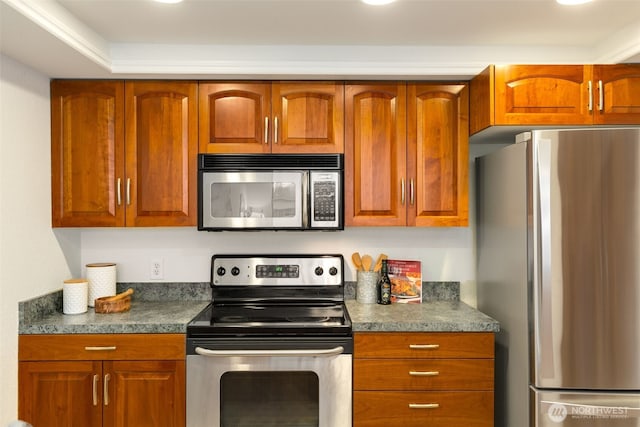 kitchen with dark countertops, appliances with stainless steel finishes, and brown cabinetry