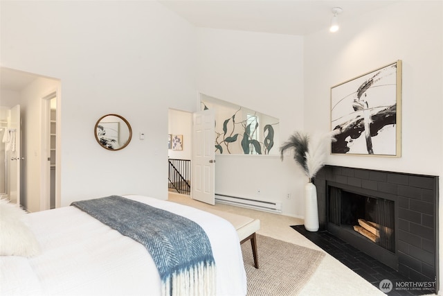 bedroom featuring a fireplace with flush hearth, carpet, a towering ceiling, and baseboard heating