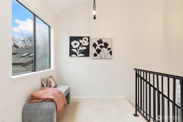 hallway featuring vaulted ceiling, carpet flooring, and baseboards