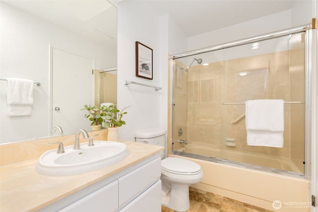 bathroom featuring vanity, toilet, and bath / shower combo with glass door