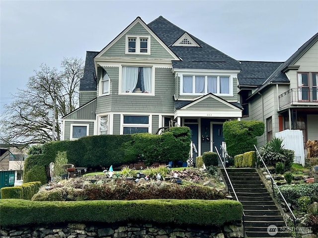 victorian home with a shingled roof and stairway