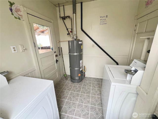 clothes washing area featuring laundry area, washing machine and dryer, and secured water heater