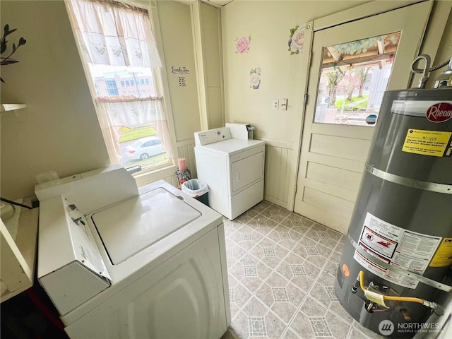 washroom with laundry area, secured water heater, washer and dryer, and wainscoting