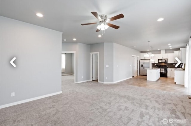 unfurnished living room with light carpet, ceiling fan, baseboards, and recessed lighting