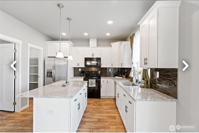 kitchen featuring black appliances, a sink, white cabinetry, and light wood-style floors