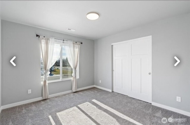 unfurnished bedroom featuring carpet, a closet, and baseboards