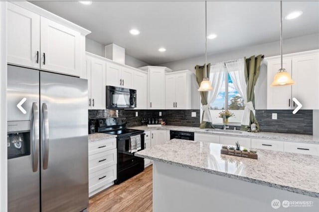 kitchen featuring light wood-style floors, white cabinetry, black appliances, and tasteful backsplash