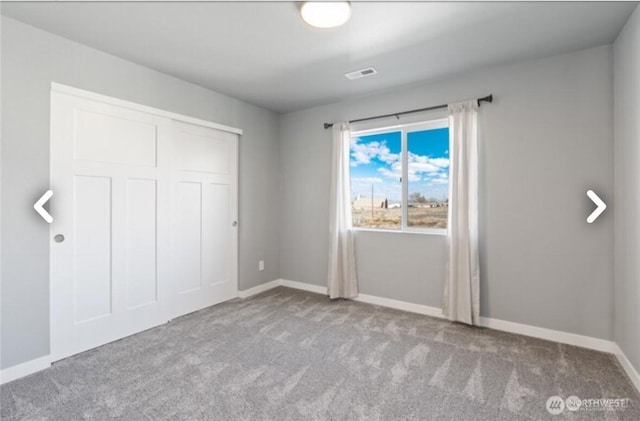 unfurnished bedroom featuring a closet, carpet, visible vents, and baseboards