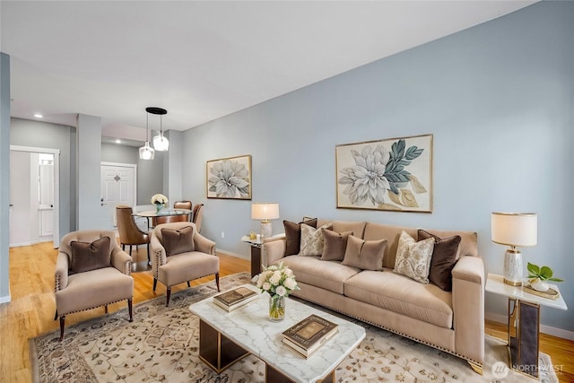 living room with light wood finished floors, baseboards, and recessed lighting