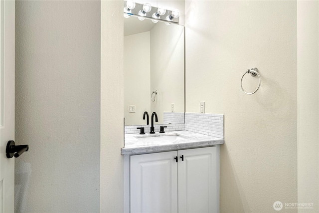 bathroom featuring tasteful backsplash and vanity