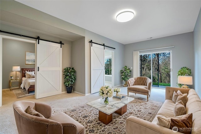 carpeted living area with baseboards and a barn door