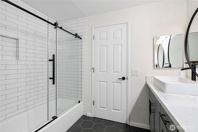 bathroom featuring combined bath / shower with glass door, tile patterned flooring, vanity, and baseboards