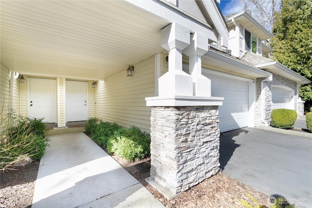 property entrance with a garage and driveway