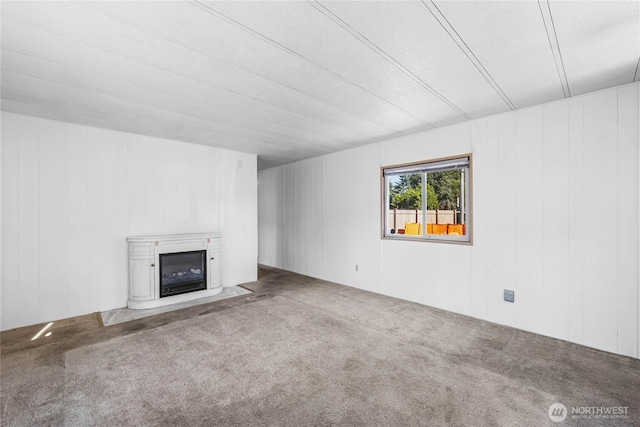 unfurnished living room with carpet and a glass covered fireplace