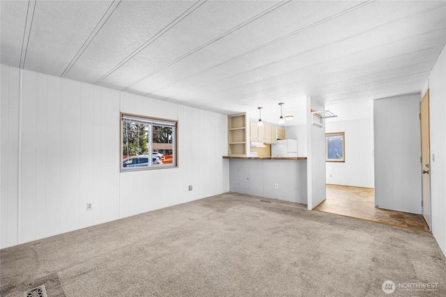 unfurnished living room featuring carpet and visible vents