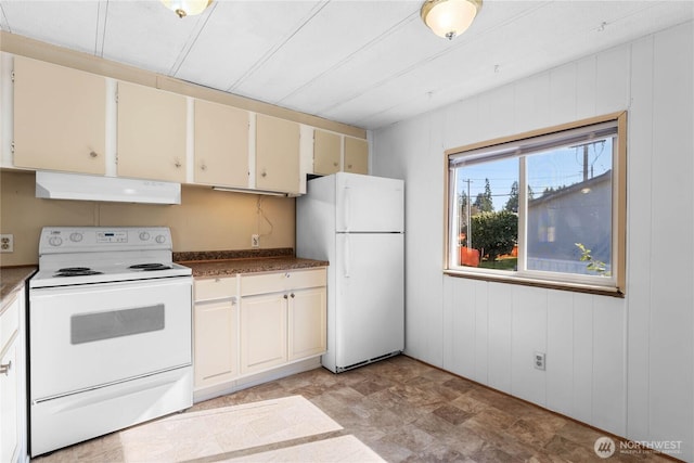 kitchen featuring wooden walls, white appliances, cream cabinets, and under cabinet range hood