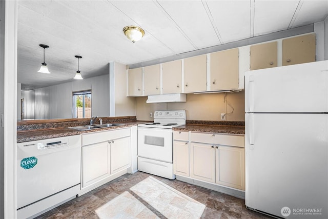 kitchen featuring white appliances, dark countertops, under cabinet range hood, pendant lighting, and a sink