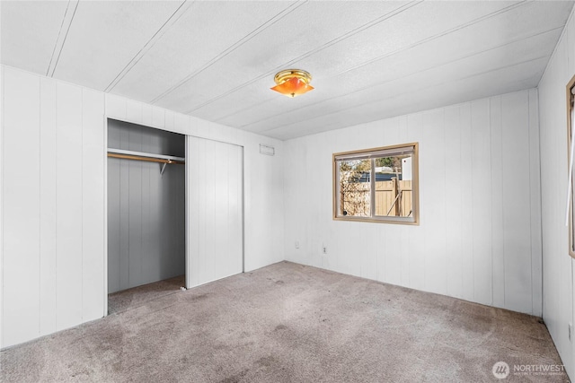 unfurnished bedroom featuring carpet and a closet