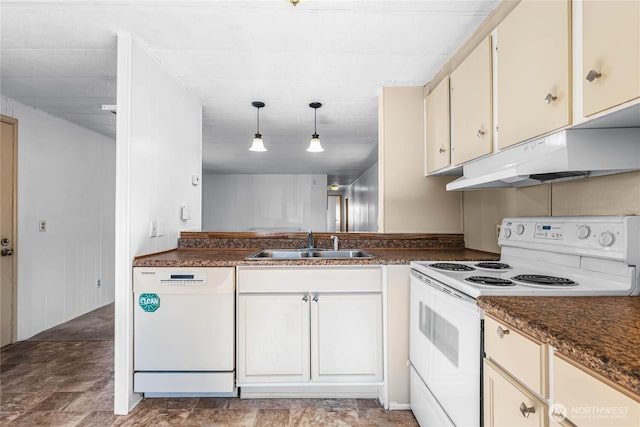 kitchen with white appliances, dark countertops, hanging light fixtures, under cabinet range hood, and a sink