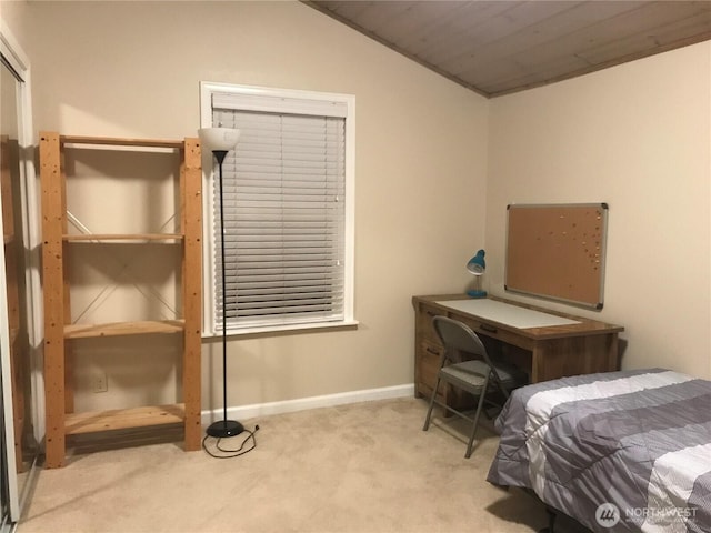 carpeted bedroom with vaulted ceiling and baseboards