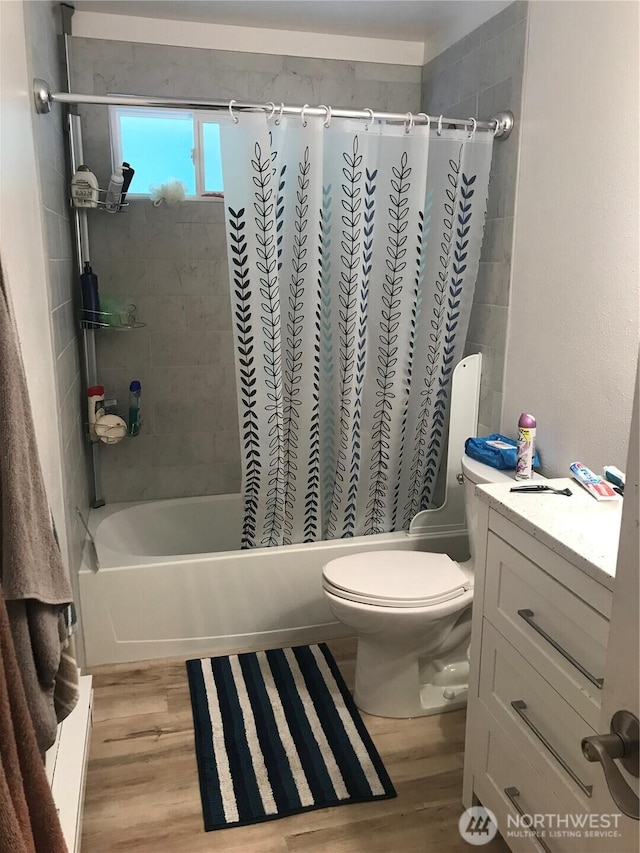 bathroom featuring shower / bath combo with shower curtain, vanity, toilet, and wood finished floors