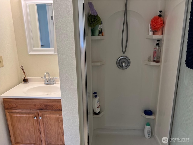 bathroom with a stall shower and vanity