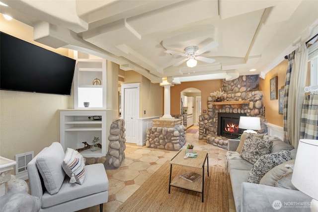 living room featuring visible vents, arched walkways, ceiling fan, ornate columns, and a fireplace