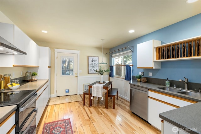 kitchen with a sink, light wood-style floors, white cabinets, double oven range, and dishwasher