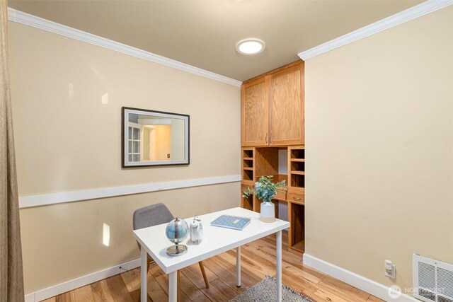 office featuring ornamental molding, light wood-style flooring, visible vents, and baseboards