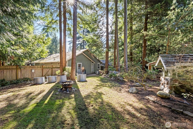 view of yard featuring fence and a fire pit