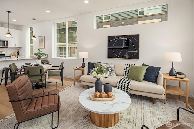 living room with recessed lighting, baseboards, and wood finished floors