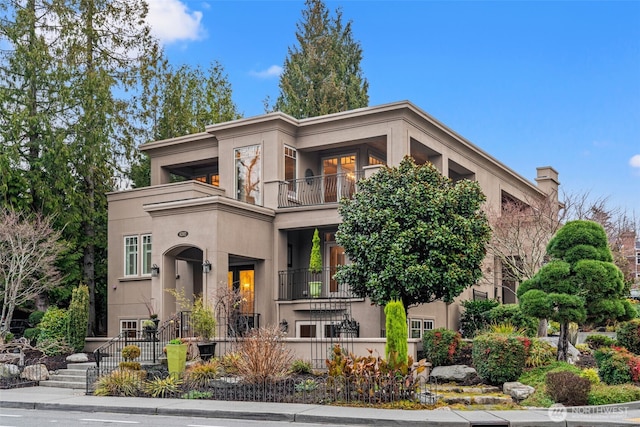 view of front of home with a balcony and stucco siding