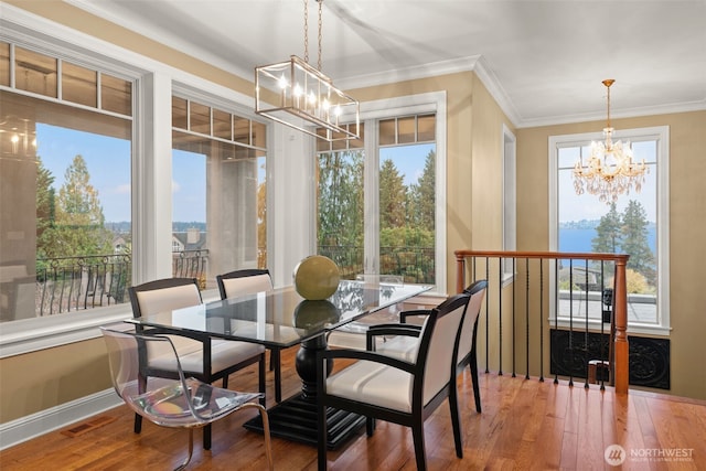 dining area with visible vents, baseboards, hardwood / wood-style floors, crown molding, and a notable chandelier