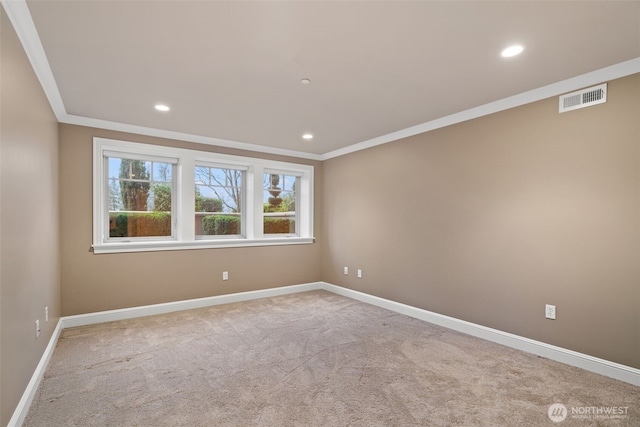 spare room with baseboards, carpet floors, visible vents, and crown molding