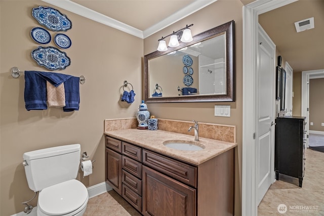 bathroom with baseboards, toilet, tile patterned floors, crown molding, and vanity