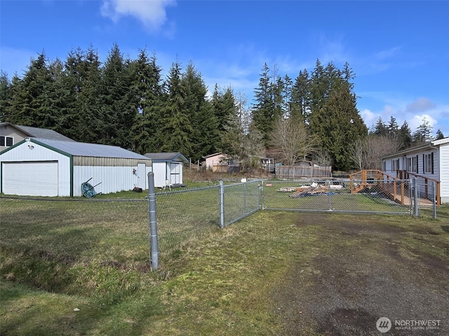 view of yard featuring a garage, an outdoor structure, and fence